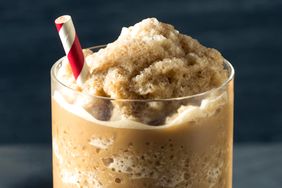 A frozen coffee beverage with a red and white striped straw