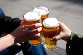 Three people toasting with glasses of beer