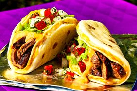 Two taco wraps on foil filled with meat cheese and vegetables