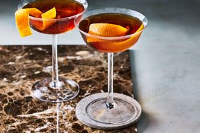 Two Adonis cocktails on a brown marble surface. 
