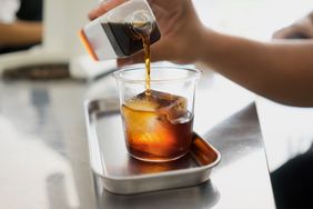Cold brew coffee being poured into a glass with ice
