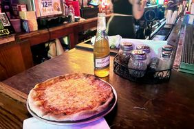 A Miller High Life with a pizza at Alligator Lounge. 