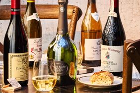 A table with various wine bottles glasses and bread