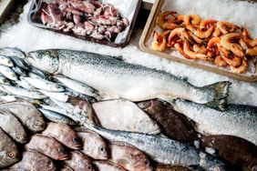 Display of assorted fresh fish and seafood on ice including salmon shrimp and various small fish