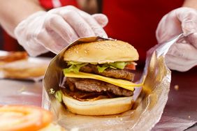 A 'Five Guys' employee wraps a hamburger. 