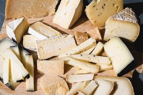 A selection of various cheese types arranged on a wooden board