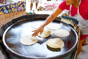Tortillas being cooked on a comal.