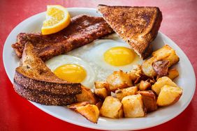 Breakfast plate with sunnysideup eggs toast home fries and sausage