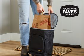 A person taking a bag out of the dbest Products Ultra Compact Cooler Smart Cart