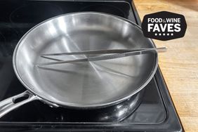 A pair of Kuchenprofi 12-inch tweezer tongues on top of a skillet.