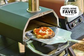 pizza peel removing a cooked pizza from the Ooni Karu 2 pizza oven