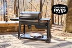 Traeger Woodridge Pro grill on an outdoor patio with bag of wooden pellets