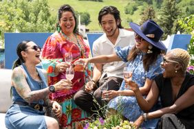 A group of people enjoying drinks together outdoors smiling and toasting suggesting a cheerful gathering
