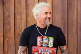 Guy Fieri holding a box of Waterloo sparkling water