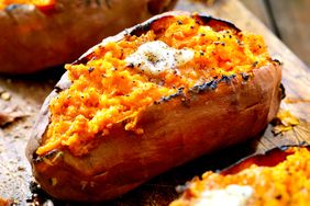 Baked sweet potato with mashed filling topped with melted butter and pepper