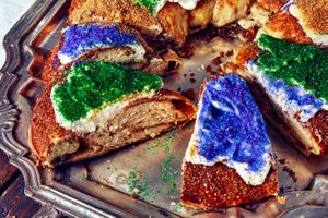 A sliced king cake on a metal platter.