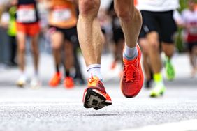 Runners lower legs in motion during a marathon emphasizing energy and movement on a city street