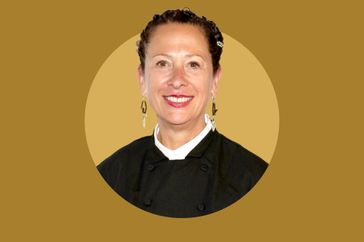 Nancy Silverton wearing a chefs jacket against a plain background