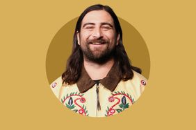 Smiling man with long hair wearing an embroidered jacket