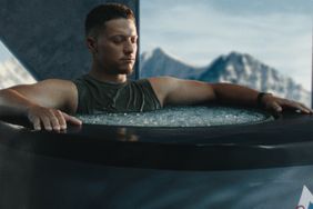 Patrick Mahomes in an ice bath outdoors with mountains in the background