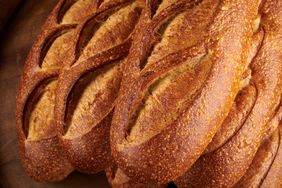 Several loaves of sourdough bread with scored tops arranged closely together