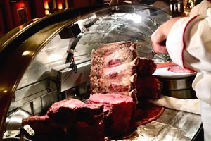 A chef carving prime rib at a steakhouse station