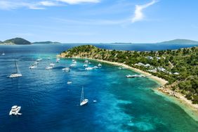 Scenic coastline with anchored boats and distant islands