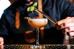 Close-up of a bartender garnishing a fresh cocktail in the pub